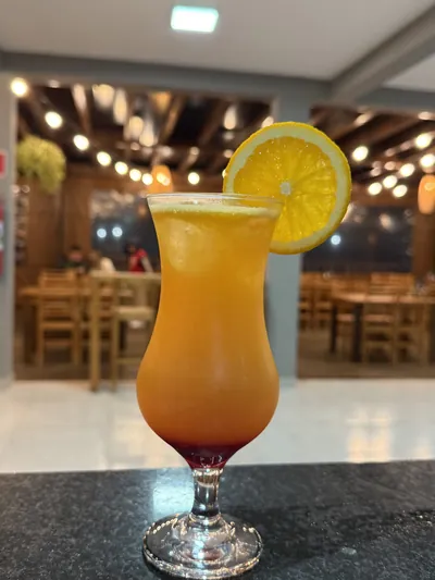 Drink alaranjado em degradê com rodela de laranja